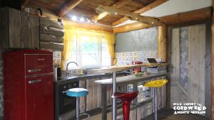 a kitchen with a red refrigerator and stools in it at Wild Cherry Cordwood / Дивите череши in Godech