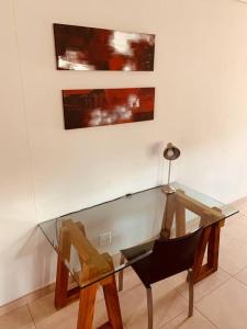 a glass table and a chair in a room at Home away from home in Windhoek
