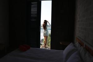 Uma mulher de vestido branco à porta. em MuchoSur Manzanillo CTG em Cartagena de Indias
