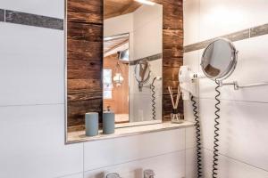un baño con espejo y lavabo en Eigerhome - The Cottage mit Wellness - GRIWA RENT AG, en Grindelwald 27 fotos más