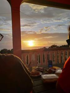 uma vista para o pôr-do-sol a partir de uma varanda com pizza em Terrasse des Manguiers : logement indépendant em Pointe-Noire