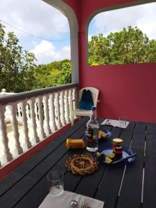 una mesa con una botella de vino en el balcón en Terrasse des Manguiers : logement indépendant, en Pointe-Noire