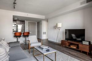 a living room with a couch and a flat screen tv at Bethesda 1br w doorman pool gym nr metro WDC-722 in Bethesda