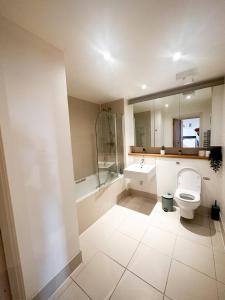 uma casa de banho com um WC, um chuveiro e um lavatório. em Shard views em Londres