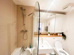 uma casa de banho com um chuveiro, um WC e um lavatório. em Shard views em Londres