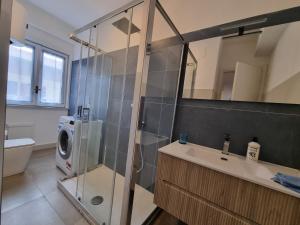een badkamer met een douche, een wastafel en een wasmachine bij La Pigna di Taormina in Mascali
