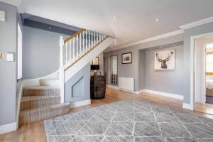 a living room with a staircase and a rug at Rosemount - Perfect for Gatherings - Kilrenny in Fife