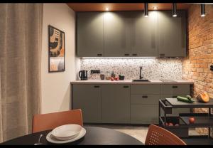 a kitchen with gray cabinets and a table with chairs at Mieszkanie w Pruszkowie in Pruszków