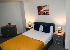 a bedroom with a bed with two night stands and two lamps at Contemporary 1 Bed Apartment in Bedford