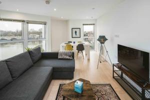 a living room with a couch and a television at 2bed flat with the view/Kingston in London