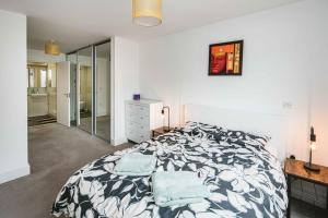 a white bedroom with a bed and a mirror at 2bed flat with the view/Kingston in London