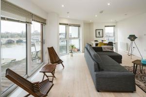 a living room with a couch and chairs and windows at 2bed flat with the view/Kingston in London