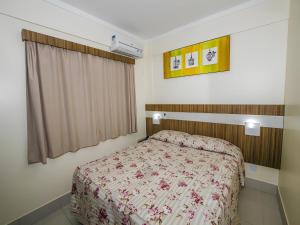 - une chambre dotée d'un lit avec un couvre-lit floral dans l'établissement L'acqua diRoma 12345 / Temporada CN, à Caldas Novas