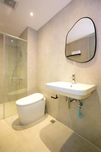 La salle de bains est pourvue de toilettes, d'un lavabo et d'un miroir. dans l'établissement Nest in Ali Homestay, à Zhongpu