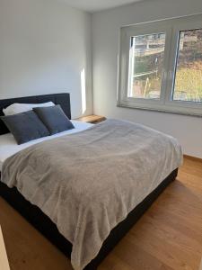 1 dormitorio con 1 cama grande y 2 ventanas en Penthouse Visp - mit großer Dachterasse und Panoramablick, en Visp