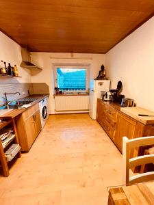 a large kitchen with wooden cabinets and a window at Familienapartment mit Balkon und Garten in Ober-Lembach