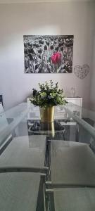 una mesa de cristal con una flor encima en Appartamento Casa Nizza - Metro Lingotto fiere by Bib's Apartments, en Turín