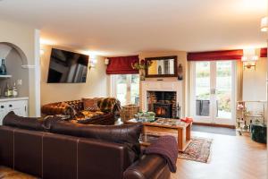 a living room with leather furniture and a fireplace at Broombank in Burley