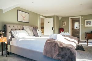 a bedroom with a large bed with white sheets at Broombank in Burley