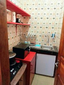 cocina pequeña con fregadero y fogones en Residence Sighaka - Studio Meublé VIP avec WiFi, Gardien, Parking, en Douala