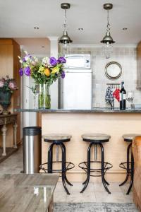 a kitchen with a counter with stools and a vase of flowers at Avemore Eikehof No 23 - with Backup Power in Stellenbosch