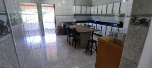 a kitchen with a counter and a table in it at Casa e quintal exclusivo Meu Xodó- rota da ferradura em Guarapari- Praia e montanha- até 4 pessoas in Guarapari +15 photos