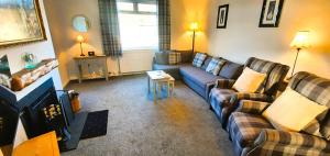 a living room with a blue couch and chairs at Tom's Place in Kirkcudbright