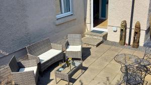 an outdoor patio with two chairs and a table at Tom's Place in Kirkcudbright