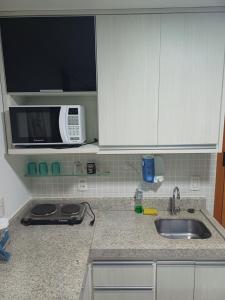 a kitchen counter with a sink and a microwave at Brookfield Tower in Goiânia