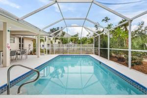 a swimming pool in a house with a glass roof at Villa Island Pearl - Roelens Vacations in Sanibel