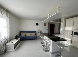 una cucina e un soggiorno con divano blu di Beau Soleil ad Aosta Altre 10 foto