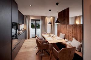 a kitchen and dining room with a wooden table and chairs at Alpin Residenzen Eichenheim Aurach bei Kitzbühel by Alpina-Holiday in Aurach bei Kitzbuhel