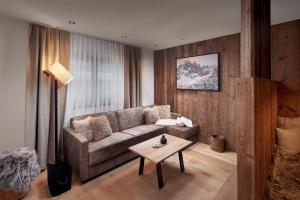 een woonkamer met een bank en een tafel bij Alpin Residenzen Eichenheim Aurach bei Kitzbühel by Alpina-Holiday in Aurach bei Kitzbuhel