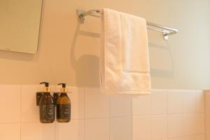 a bathroom with a towel and two bottles of soap at Huishotel Bed bij Bort in Ommen