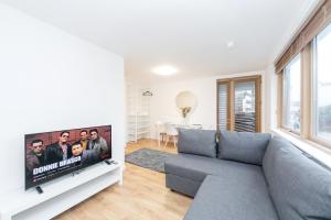 a living room with a couch and a flat screen tv at St Pancras Residence 1 BR Flat Sleeps 4 in London