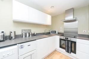 a white kitchen with white cabinets and appliances at St Pancras Residence 1 BR Flat Sleeps 4 in London