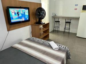 um quarto com uma televisão e uma cama com uma ventoinha em Studio mobiliado em São Paulo Vila Guilherme - Expo Center Norte em São Paulo