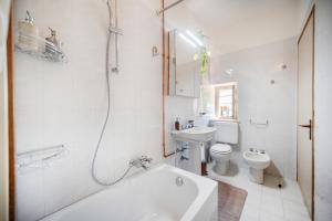 La salle de bains est pourvue d'une baignoire, de toilettes et d'un lavabo. dans l'établissement Villa Calicantus, à Bardolino