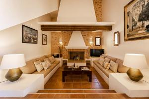 un soggiorno con divano e camino di CAN NOVES - Villa de 5 suites 31 y 9 a Sant Francesc Xavier