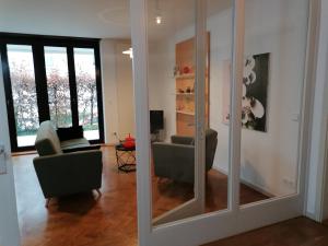een woonkamer met een spiegel en een stoel bij Architekten Villa in Theaternähe in Meiningen