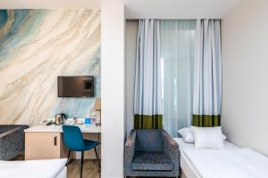 ブダペストにあるアトリウム ファッション ホテルのベッドとデスクが備わるホテルルームです。