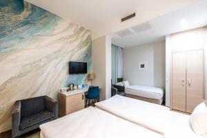 a hotel room with two beds and a tv at Atrium Fashion Hotel in Budapest