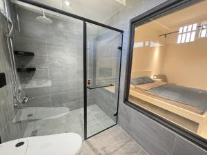 a bathroom with a glass shower and a bed at 生活就是壽豐Villa民宿 in Guangrong