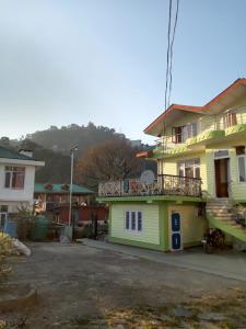 une maison avec un balcon au-dessus dans l'établissement Akash Homestay, à Shimla