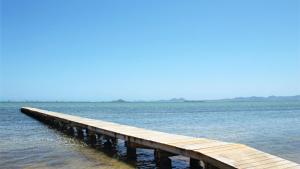 a wooden pier in the middle of the water at Bungalows Mar Menor, paz a orillas del mar in San Javier