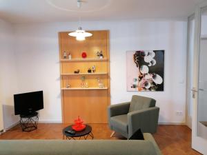 uma sala de estar com um sofá e uma televisão em Architekten Villa in Theaternähe em Meiningen