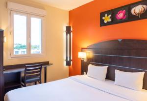 Habitación de hotel con cama y escritorio en B&B HOTEL Agen Castelculier en Castelculier