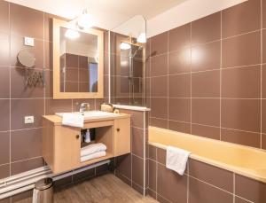 a bathroom with a sink and a mirror at Résidence Pierre & Vacances Les Bergers in L'Alpe-d'Huez