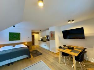 a bedroom with a bed and a table and a kitchen at Apartmaji Kotnik in Kranjska Gora