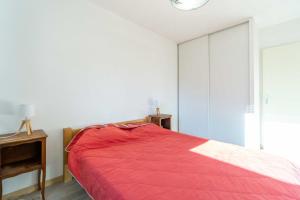 a bedroom with a red bed and a window at Bel appartement à la montagne in Séez
